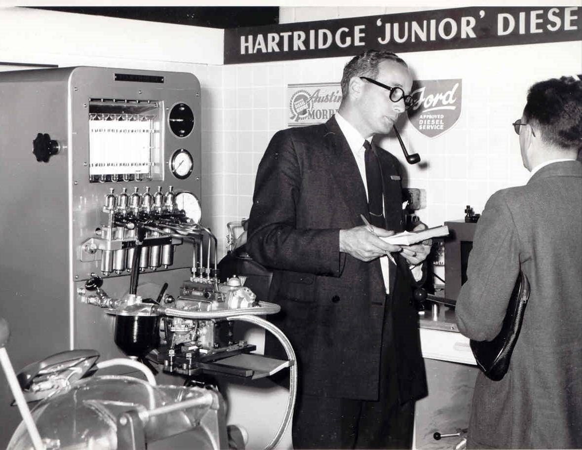 businessmen observing hartridge machine in black and white