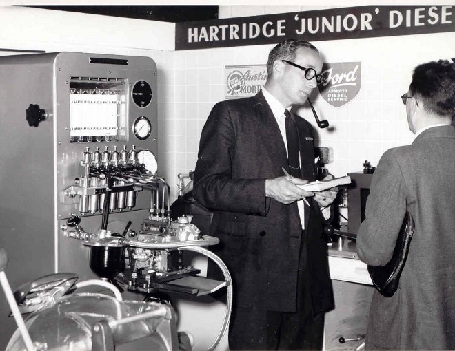 businessmen observing hartridge machine in black and white